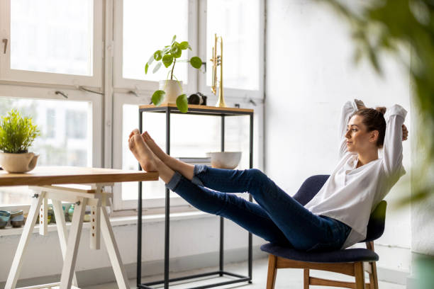 istock Young woman relaxing in office with her bare feet on desk 1299946731
