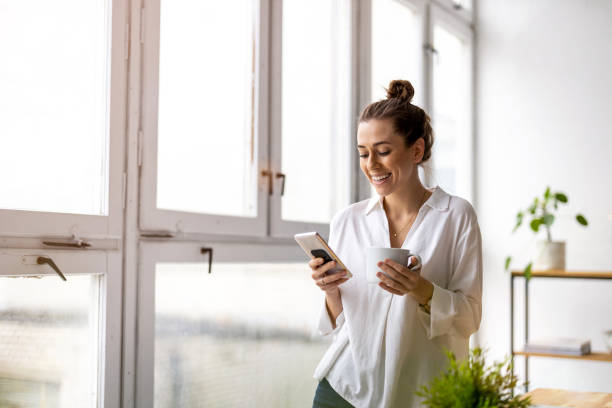 istock Creative business woman using smartphone in loft office 1299946859