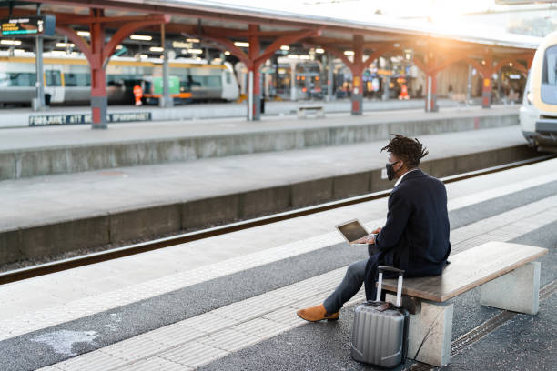 istock Businessman using his laptop at the train station 1299948482