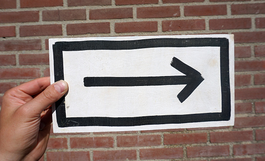 Sign arrow to the right holding in a hand