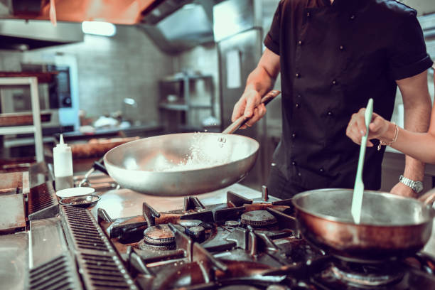 istock Cooks Preparing Fried Rice And Sauce And Modern Restaurant Kitchen 1299952560