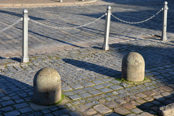 ancient, barrier, bollard, brown, chain, circle, cobblestone, construction, cube, cubes, curb, cylinder, disaster, divide, dividing, diving, fence, granite, gray, heavy, hemisphere, history, incident, iron, line, lot, metal, mosaic, multiple, old, ornamental, parking, pavement, paving, pedestrian, post, protection, railing, row, school, separation, shape, sidewalk, sphere, stone, street, sunny, terrorist, traffic, yard