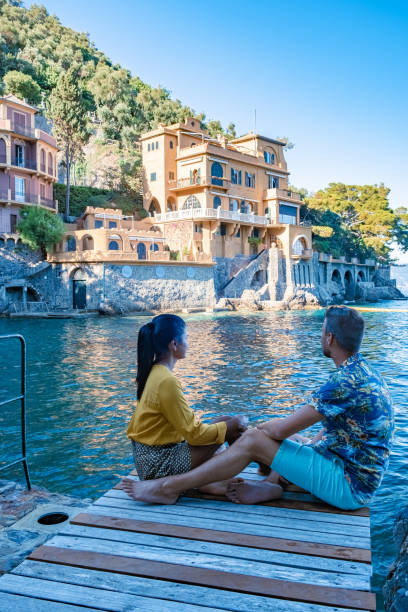 Beautiful sea coast with colorful houses in Portofino, Italy Europe Portofino in Liguria, Italy Beautiful sea coast with colorful houses in Portofino, Italy Europe Portofino in Liguria, Italy. Genoa Couple mid age man and woman visiting Italy during vacation santa margherita ligure italy stock pictures, royalty-free photos & images