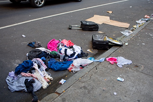 New York, NY, USA - Feb 1, 2021: A suitcase thrown open with its contents scattered on the street