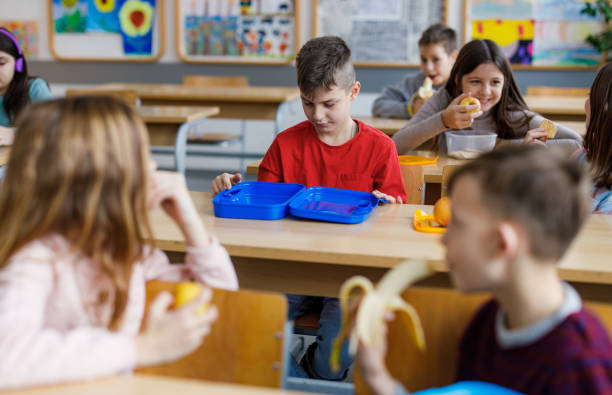 istock Child in classroom looking in his empty launch box 1299957412