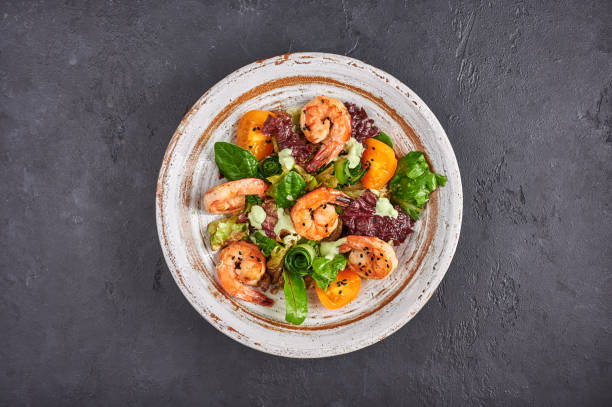 ensalada casera con camarones fritos, tomates amarillos, rúcula, espinacas, lechuga y salsa - salad shrimp prawn prepared shrimp fotografías e imágenes de stock