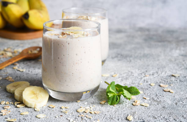 Smoothie with banana and oatmeal for breakfast on a light concrete background. Detox menu. stock photo