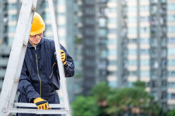 Male worker adjusting ladder at construction site
