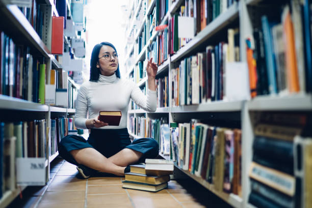 istock Woman choosing books in library 1299961662