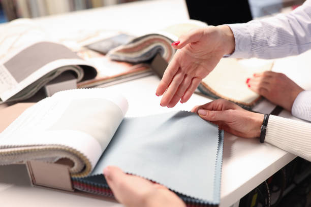 istock Women holding catalog and choosing fabrics closeup 1299963544