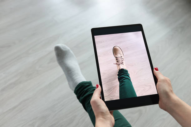 Woman holding tablet over her leg and trying on shoes closeup Woman holding tablet over her leg and trying on shoes closeup. Online dressing room concept getting dressed photos stock pictures, royalty-free photos & images