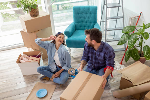 istock Couple packing their possessions into cardboard boxes while moving house 1299963704