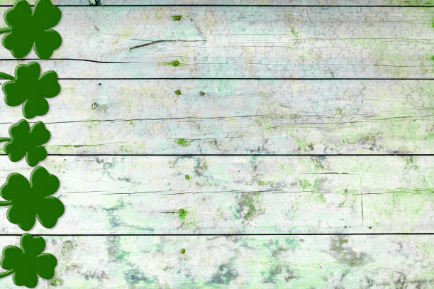 istock St Patricks day background. Shamrocks over a light green wood background. 1299964716