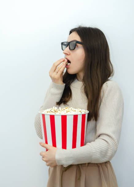 istock a young beautiful woman brunette with a popcorn 1299964830