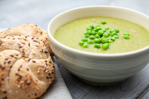 Healthy lunchtime meal of pea and ham soup, with seeded kaiser rolls