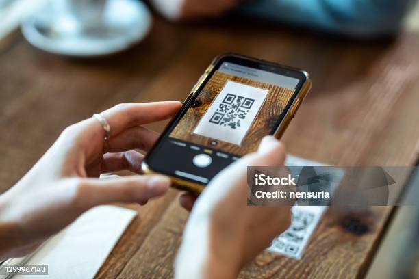 Young Woman Hands Using The Smart Phone To Scan The Qr Code To Select Food Menu In The Restaurant Stock Photo - Download Image Now
