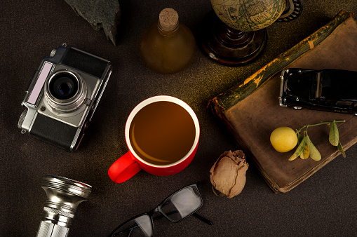 Vintage rustic theme table with coffee cup and still life objects.