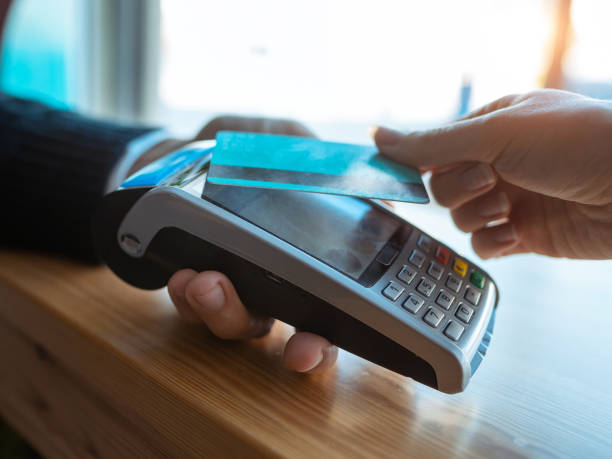 istock Customer using her credit card to make payment with electronic reader in the restaurant. 1299967788