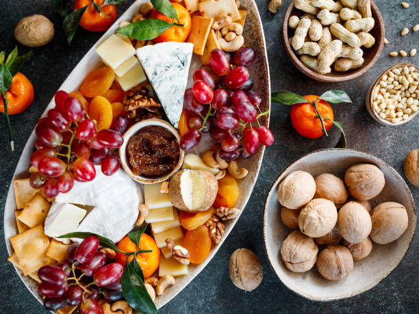 istock Big cheese board with appetizer assortment. Grape, cheese, nuts, jam and bread. 1299968728