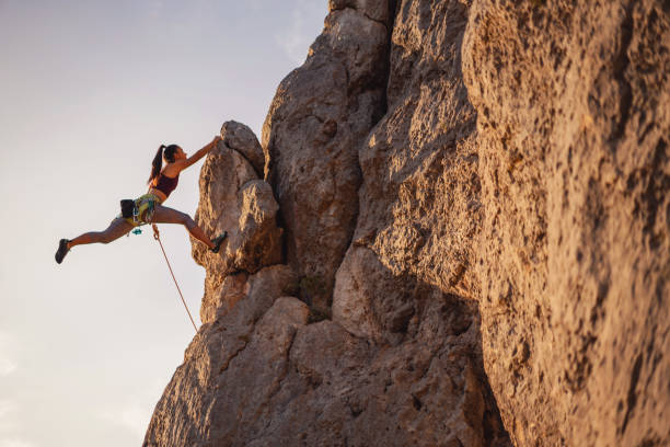 istock One female climber on the rock mountain 1299970338