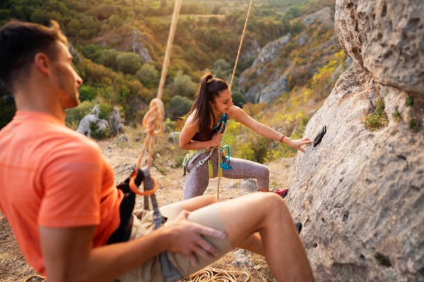 Young Caucasian couple climbing together.
