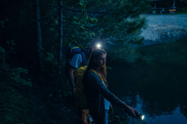 istock Two hikers holding flashlight in the nature 1299971598