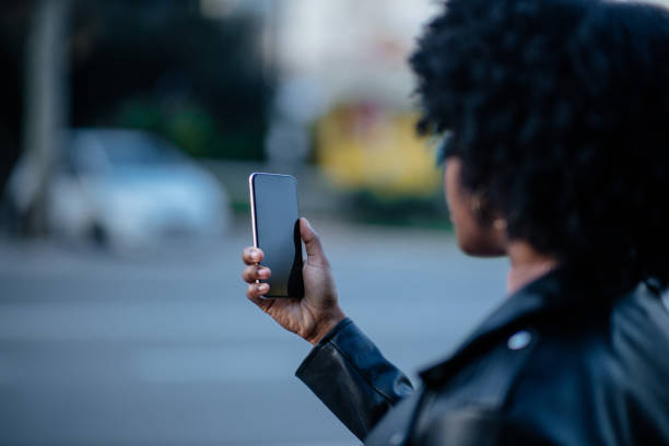 istock Young black woman using phone and while out in the city 1299972871