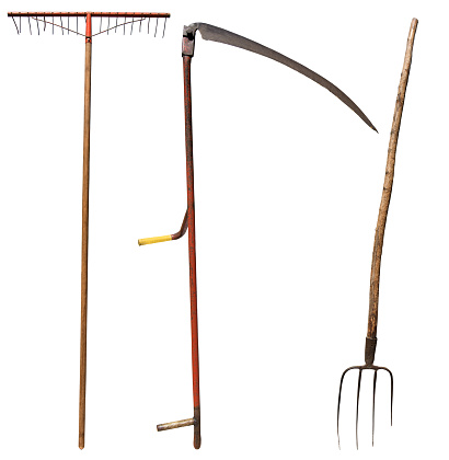 Scythe, Pitchfork and a Rake. Vintage gardening equipment isolated on white background. Italy, photography.
