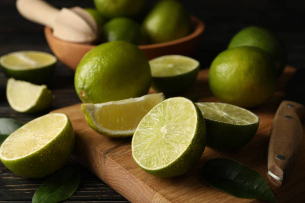 istock Bowl and board with lime on wooden background, close up 1299974540