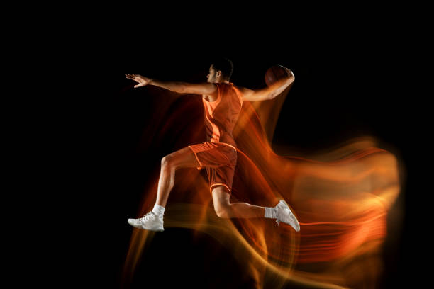 アクションでチームの若いアラビアのバスケットボール選手、混合光の中で黒の背景に隔離された動き。スポーツ、運動、エネルギー、ダイナミックのコンセプト。 - basketball team sports healthy lifestyle isolated objects ストックフォトと画像