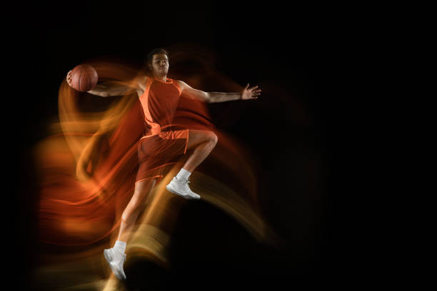 アクションでチームの若いアラビアのバスケットボール選手、混合光の中で黒の背景に隔離された動き。スポーツ、運動、エネルギー、ダイナミックのコンセプト。 - basketball team sports healthy lifestyle isolated objects ストックフォトと画像