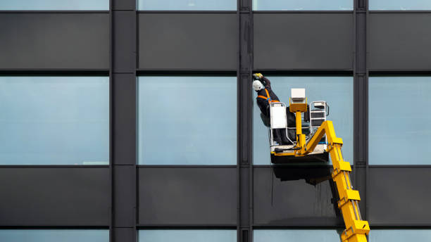 Male window cleaner cleaning glass windows on modern building high in the air on a lift platform. Worker polishing glass high in the air Male window cleaner cleaning glass windows on modern building high in the air on a lift platform. Worker polishing glass high in the air double hung window stock pictures, royalty-free photos & images