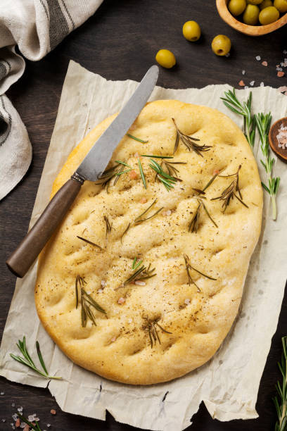 italienische traditionelle focaccia brotbacken mit aromatischen gewürzen und rosmarin auf alten hölzernen rustikalen tisch hintergrund. ansicht von oben. - italian cuisine gluten free food tomato herb stock-fotos und bilder