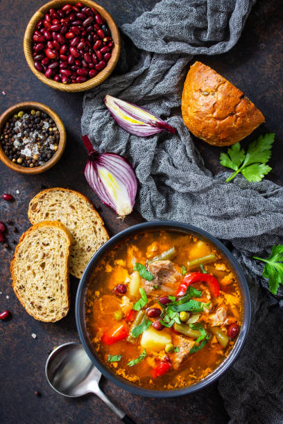 istock Homemade Meat Tomato soup with beef and bean stew, vegetables on a stone tabletop. Top view flat lay. 1299977025