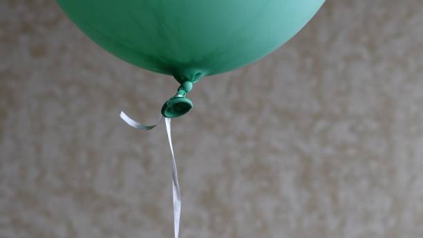 Man with glasses blowing up a balloon