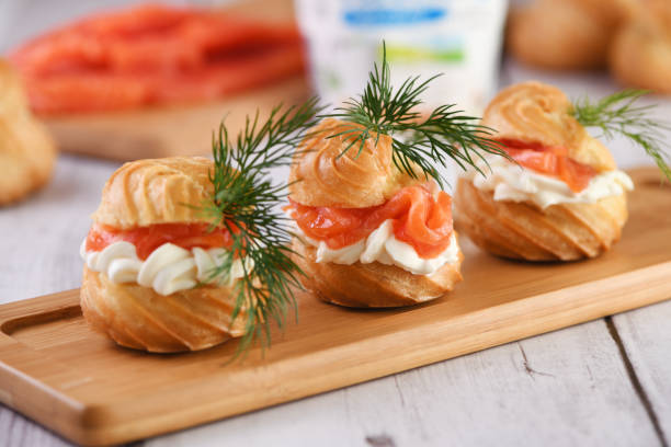 Profiteroles stuffed with cream cheese and salmon, decorated with a sprig of dill. Close-up stock photo