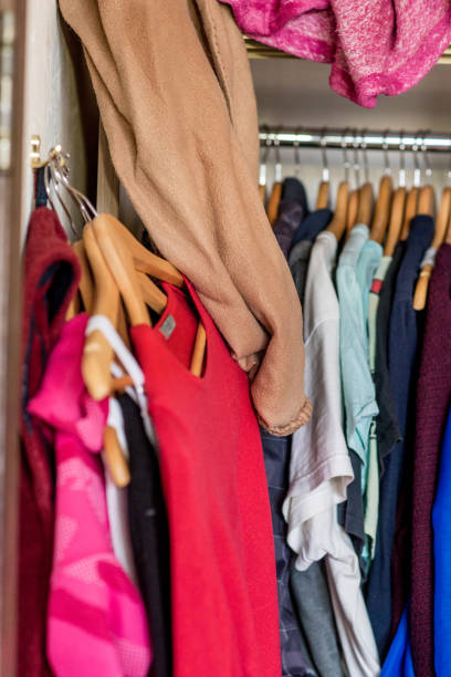 istock Mess in the wardrobe. Decluttering wardrobe. Sorting second-hand clothes for recycling. 1299979437