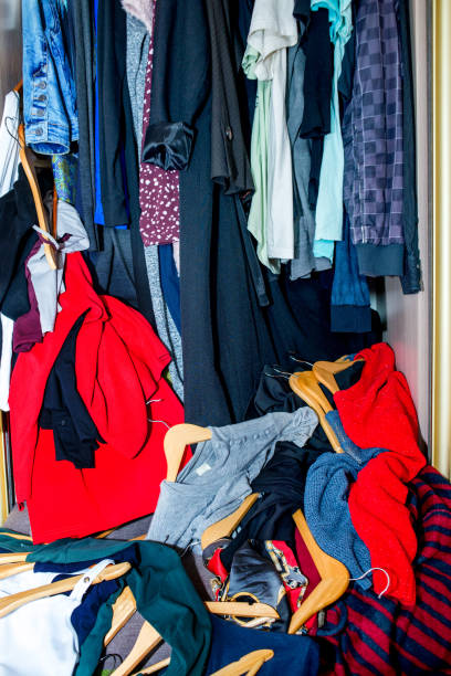 istock Mess in the wardrobe. Decluttering wardrobe. Sorting second-hand clothes for recycling. 1299979452