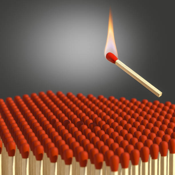 istock lit match is about to fall on a group of matches. 1299979491