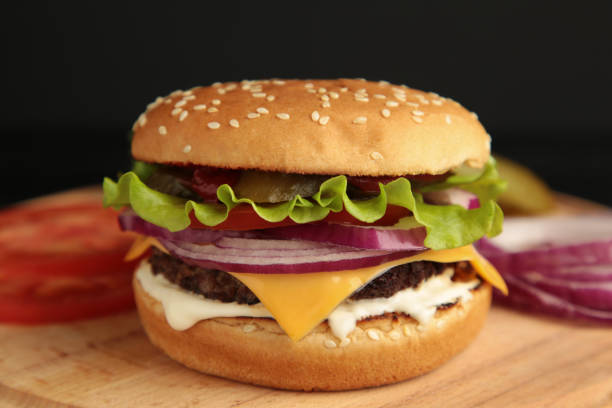 istock Fresh tasty burger and ingredients on a dark background. 1299979615