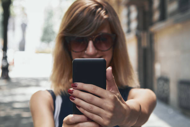 istock Woman using modern smartphone on the street. 1299980015
