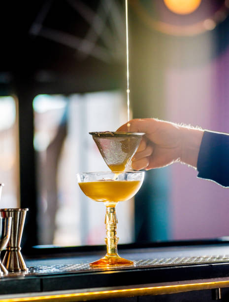 istock bartender pours a cocktail into a glass 1299980690