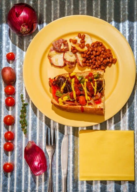 Sausage Onions Peppers Hoagie Sausage onions and peppers hoagie sandwich with side of baked beans and German potato salad torpedo sandwich stock pictures, royalty-free photos & images