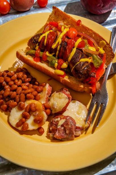 Sausage Onions Peppers Hoagie Sausage onions and peppers hoagie sandwich with side of baked beans and German potato salad torpedo sandwich stock pictures, royalty-free photos & images