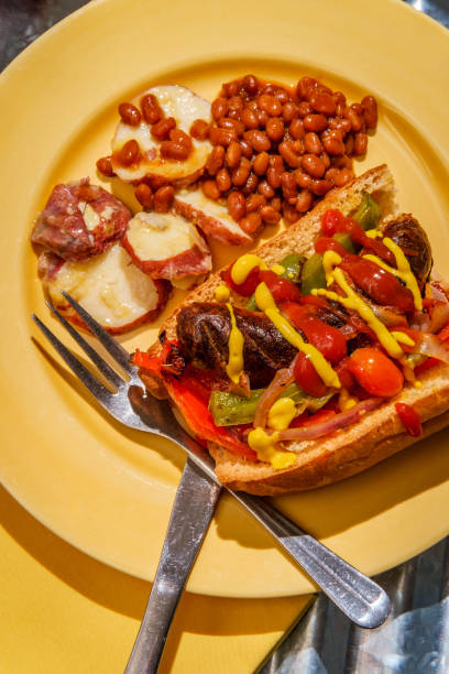 Sausage Onions Peppers Hoagie Sausage onions and peppers hoagie sandwich with side of baked beans and German potato salad torpedo sandwich stock pictures, royalty-free photos & images