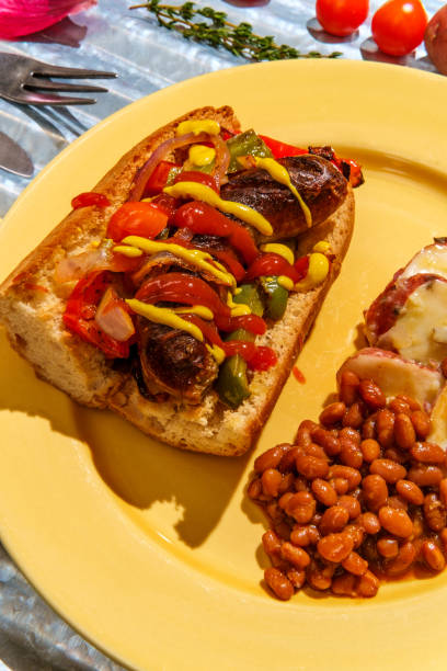 Sausage Onions Peppers Hoagie Sausage onions and peppers hoagie sandwich with side of baked beans and German potato salad torpedo sandwich stock pictures, royalty-free photos & images
