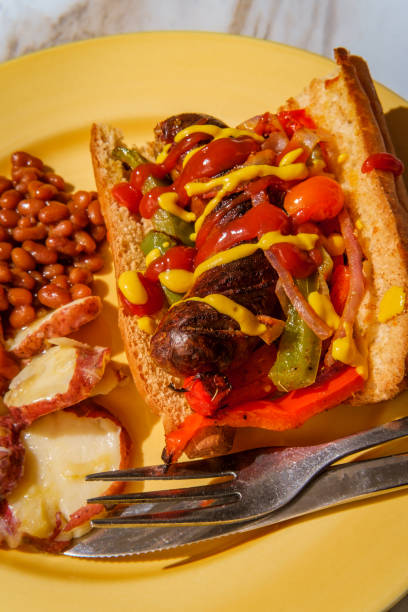 Sausage Onions Peppers Hoagie Sausage onions and peppers hoagie sandwich with side of baked beans and German potato salad torpedo sandwich stock pictures, royalty-free photos & images