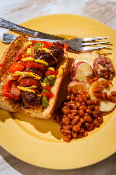 Sausage Onions Peppers Hoagie Sausage onions and peppers hoagie sandwich with side of baked beans and German potato salad torpedo sandwich stock pictures, royalty-free photos & images