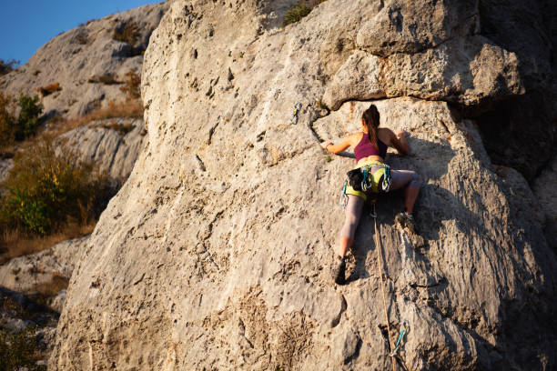 One climber straddling another climber on the upslope ridges of the Devils Tower in Wyoming