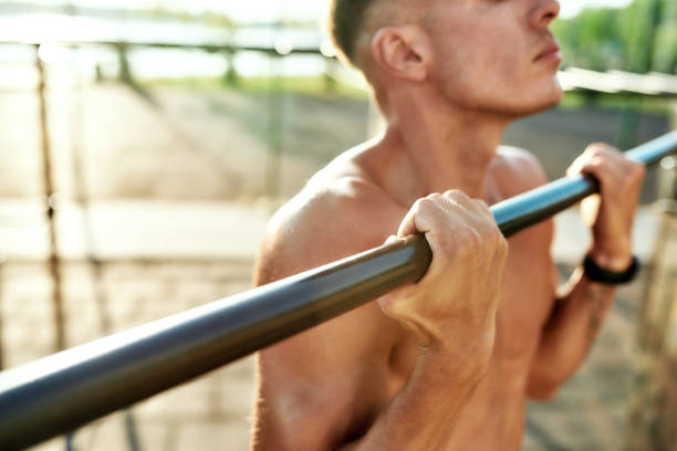 istock Young athlete on horizontal bar during workout on sport ground 1299981220